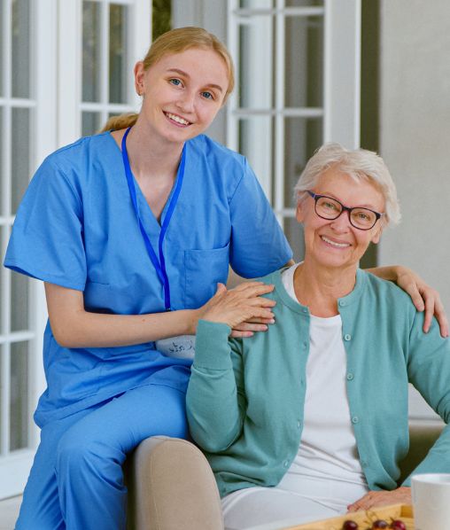 Smiling young blonde nurse in uniform takes care of woman